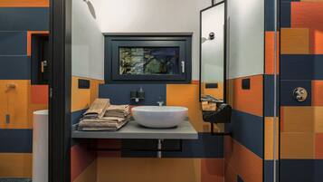 A modern bathroom with a white sink, a mirror, and a towel rack.