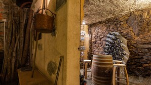 A rustic cellar with stone walls, wooden barrels, and a wine rack. - Cà Rossa Suite and Breakfast (Montagna in Valtellina)