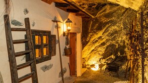 A rustic stone interior with a wooden ladder, a bench, and a small table. - Cà Rossa Suite and Breakfast (Montagna in Valtellina)