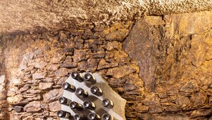 A rustic interior with a stone wall, a large wooden barrel, and a unique seating arrangement with a metal structure and stools. - Cà Rossa Suite and Breakfast (Montagna in Valtellina)