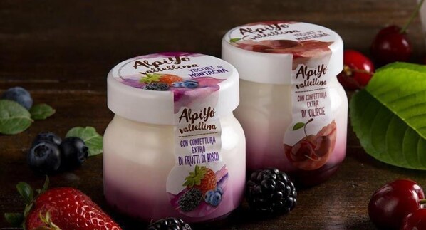 Deux pots de yaourt Alpiyo, dont les étiquettes indiquent les saveurs, comme la fraise et la mûre.
