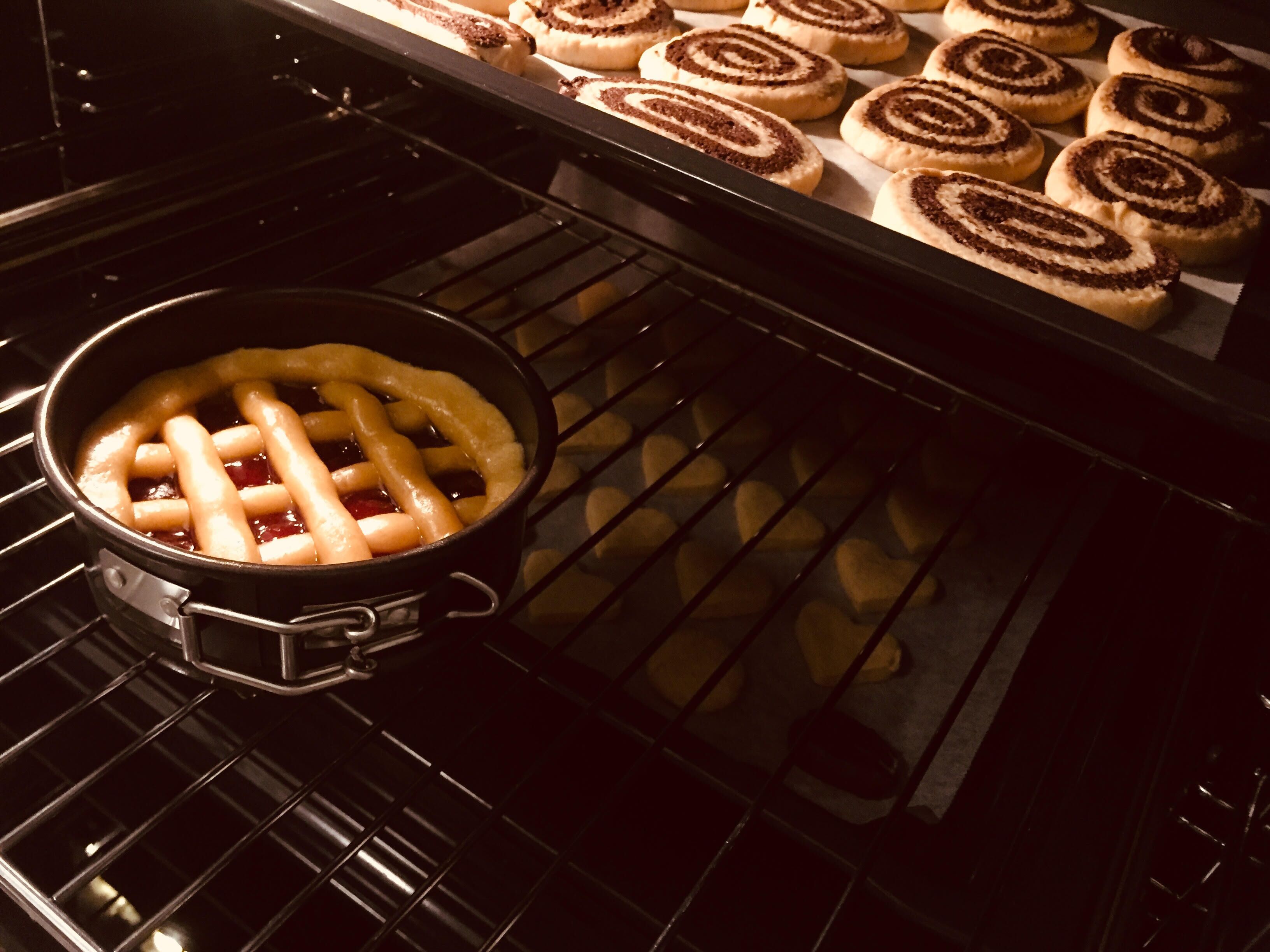 A kitchen with a baking tray of pastries and a pie in a pot.