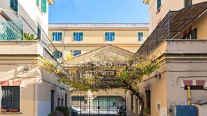 A narrow alleyway with a covered entrance, flanked by buildings with balconies and windows. - St. Joseph apartment 47 (Roma)