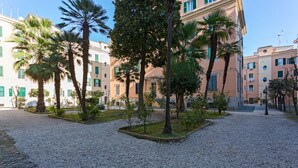 A courtyard with palm trees and a gravel path. - St. Joseph apartment 47 (Roma)