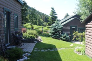 Eine Blockhütte mit einer Terrasse und einem Garten.