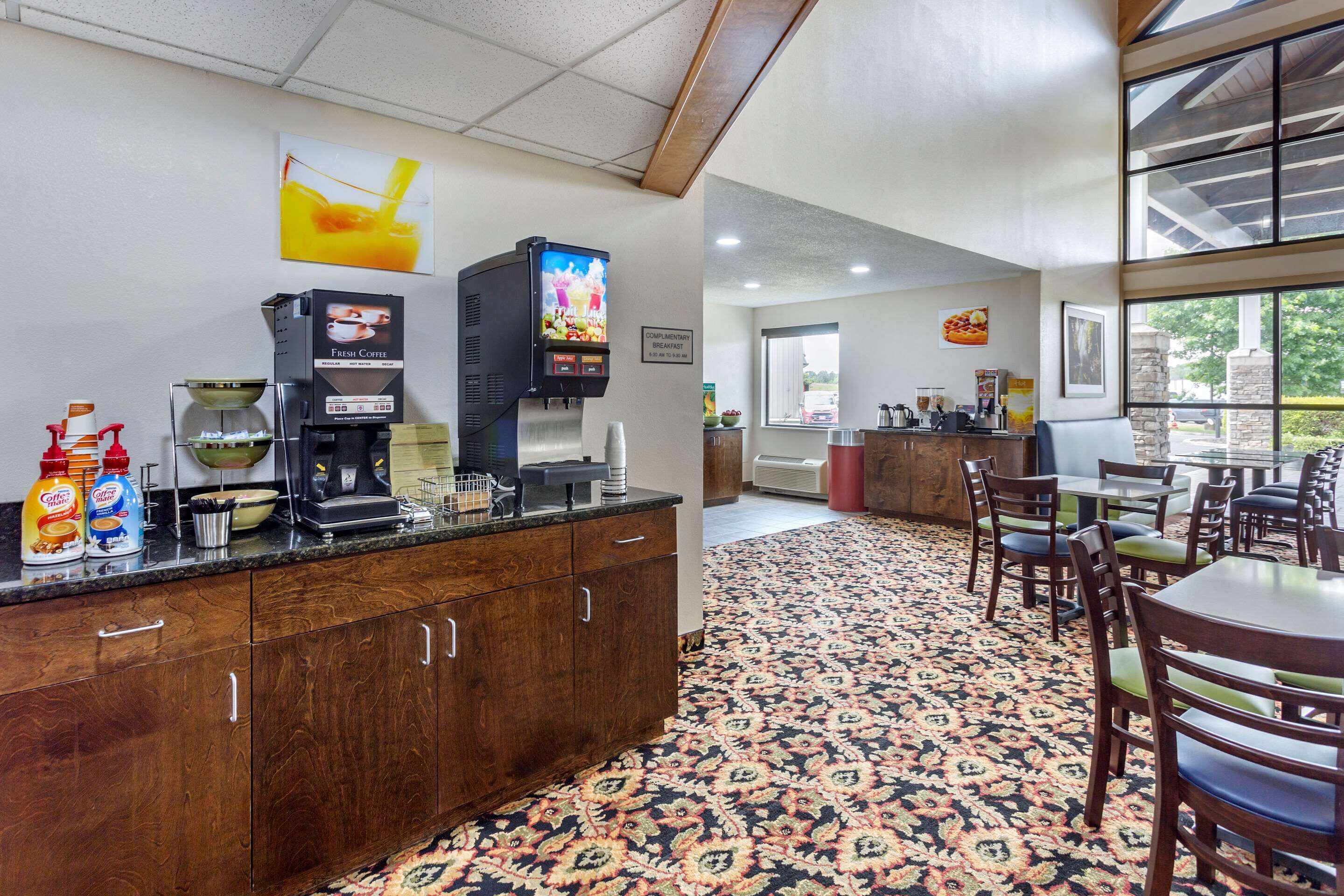 A breakfast area with a coffee machine, a TV, and a counter with coffee and cereal cartons.