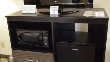 Un minibar con una TV a schermo piatto, un forno a microonde e un mini-frigorifero.