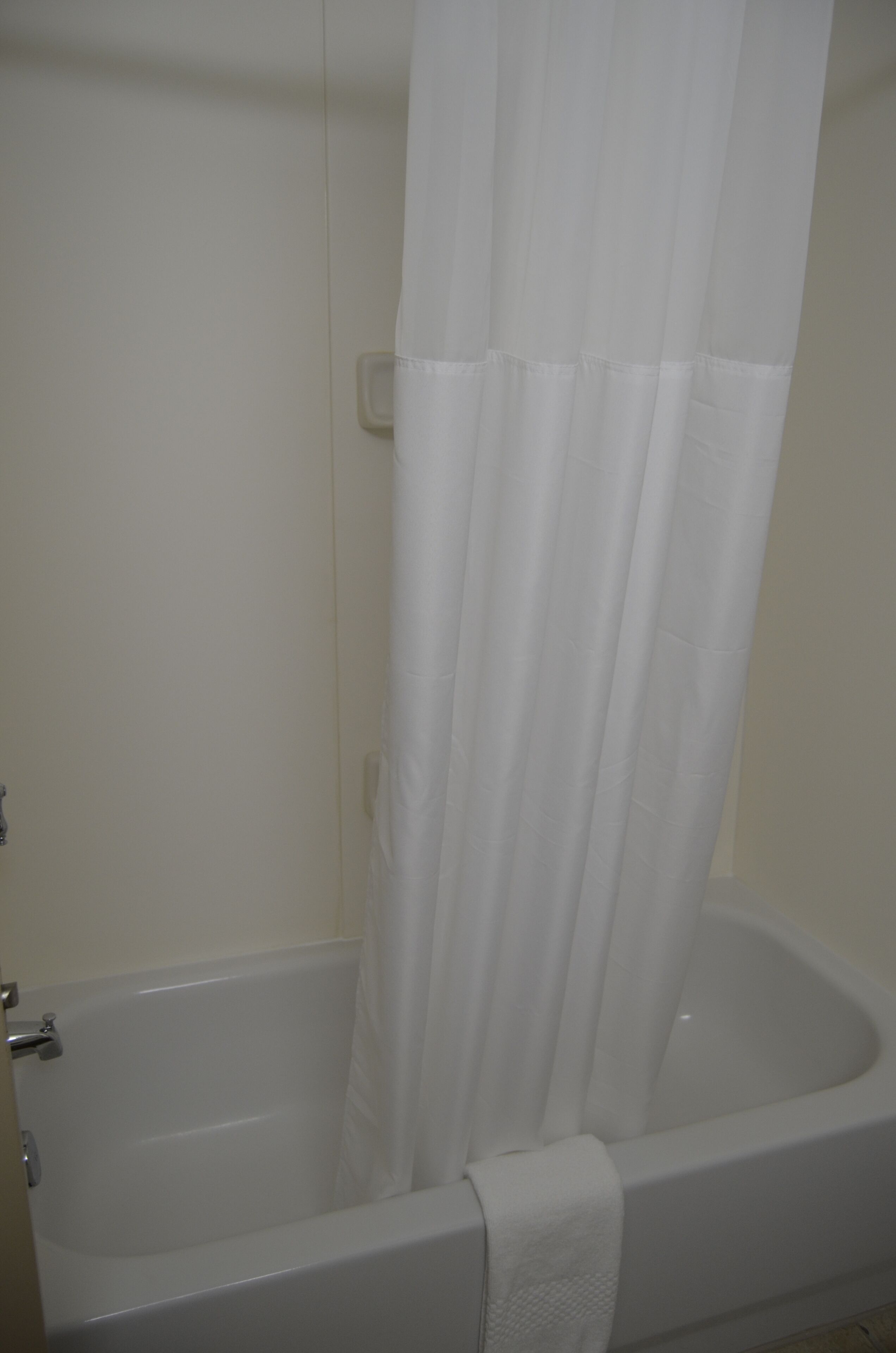 Una bañera blanca con cortina de ducha.