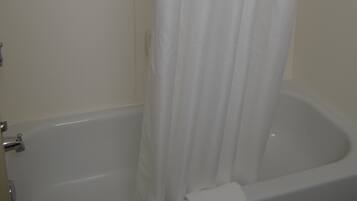 Una bañera blanca con cortina de ducha.