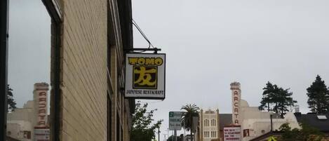 A street view with a Japanese restaurant sign, parked cars, and a building with a sign that reads "ARCATA."