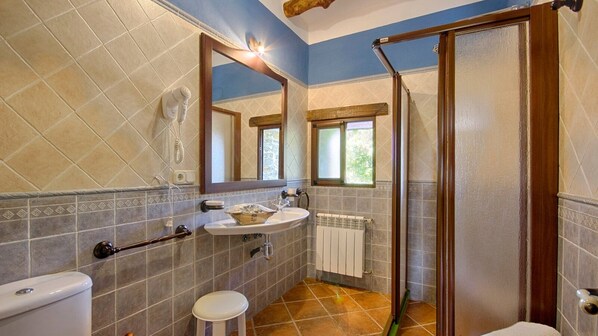 Une salle de bain comprenant des toilettes, un lavabo et un espace douche.