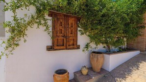 A white wall with a wooden window and two large pots. - Ramírez Almáchar by Ruralidays (Málaga)