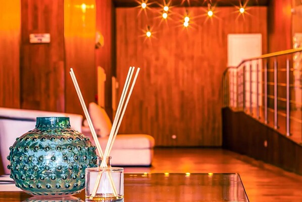 A wooden interior with a glass table, a decorative vase, and a glass with reed sticks. - Best Condominium Ocean View | PH Boutique Quartier del Mar (Ciudad de Panamá)