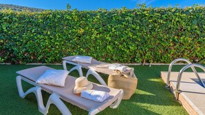 A poolside area with lounge chairs, towels, a hat, and a bag. - Casa Rural La Cañada Villanueva de Algaidas by Ruralidays (Málaga)