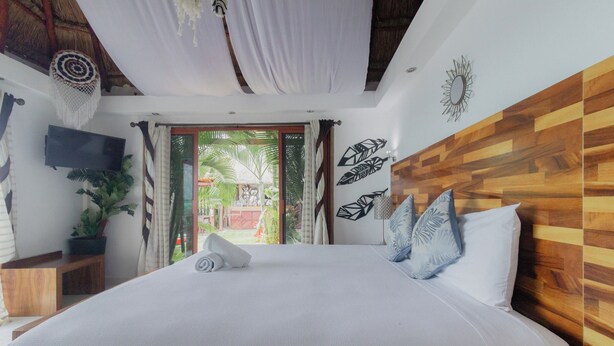Un dormitorio con una cama grande, cabecera de madera y vista al exterior.