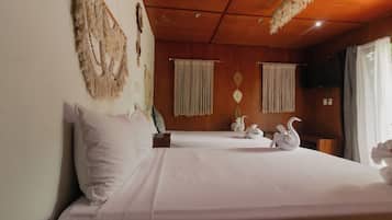 A hotel room with a large bed, a wooden ceiling, and a window with curtains.