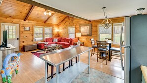 A log cabin interior with a living area, dining space, and kitchen. - High Peak Heaven: Cozy Log Cabin on 1 Acre! (Windham)