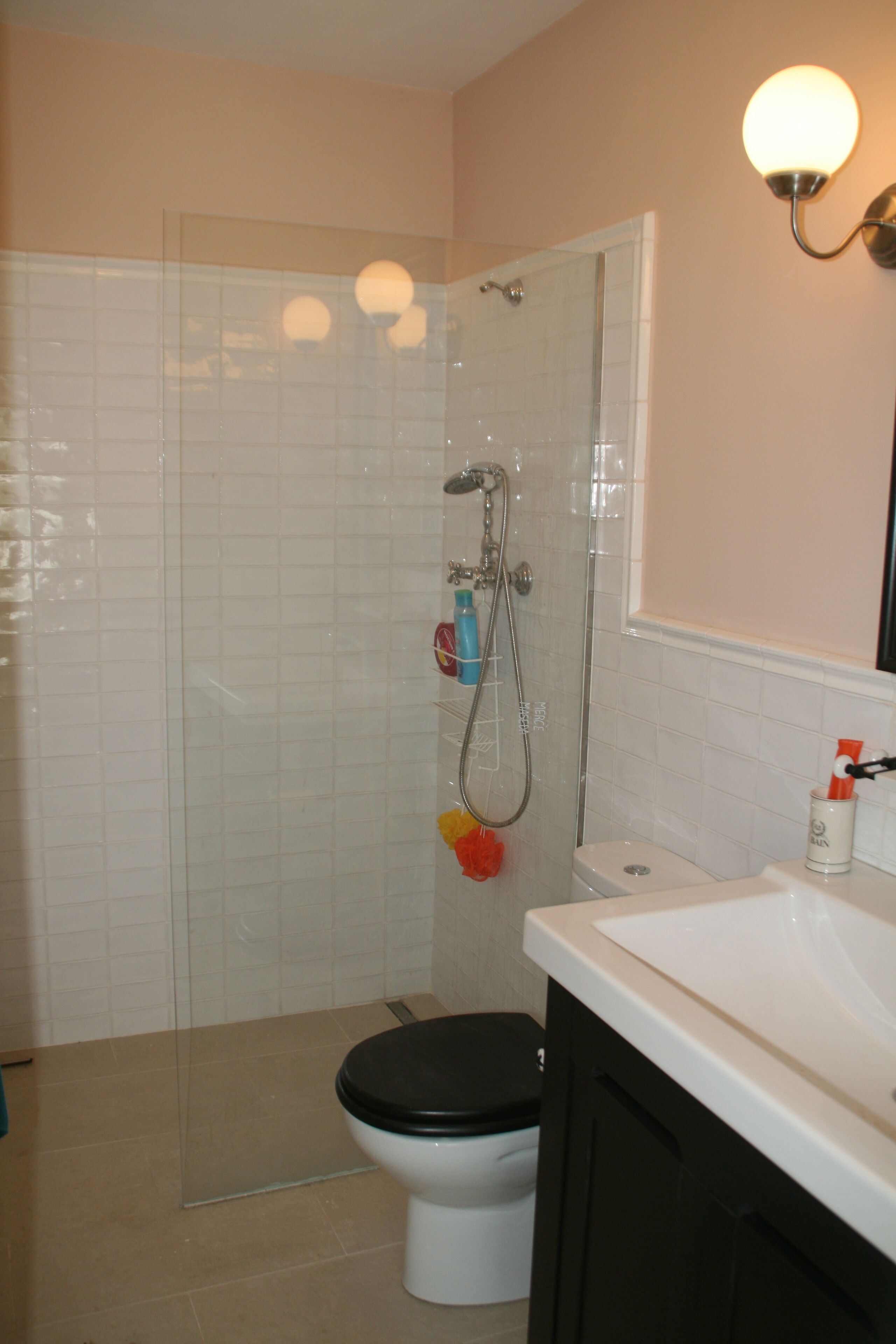 Un baño con ducha, inodoro y lavabo.