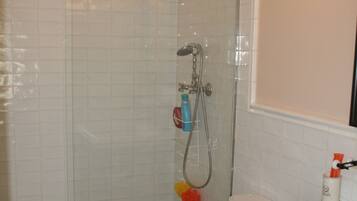 Un baño con ducha, inodoro y lavabo.