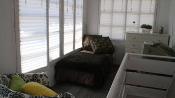 Un dormitorio con cama, cómoda y ventana con persianas.