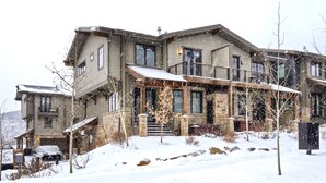 A multi-story stone house with a covered porch and a car parked in front. - Modern Townhome in Central Location with Private Hot Tub & Luxury Amenities! (Park City)