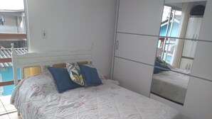 A bedroom with a bed, a wardrobe, and a mirror. - House 2 people with sea view 15 minutes from the beach, (São José)