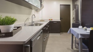 Eine moderne Küche mit eingebautem Geschirrspüler, einer Spüle und einem Essbereich mit Tisch und Stühlen.