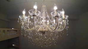 A chandelier with multiple arms and crystal decorations in a room.