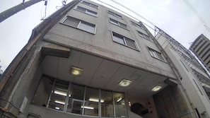 A multi-story building with a flat roof, large windows, and visible structural beams.