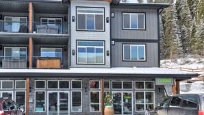 A multi-story building with a storefront and a balcony. - New 2Bd 2Bth , Ski/Ski Out Condo with Private Hot Tub! (Sun Peaks)