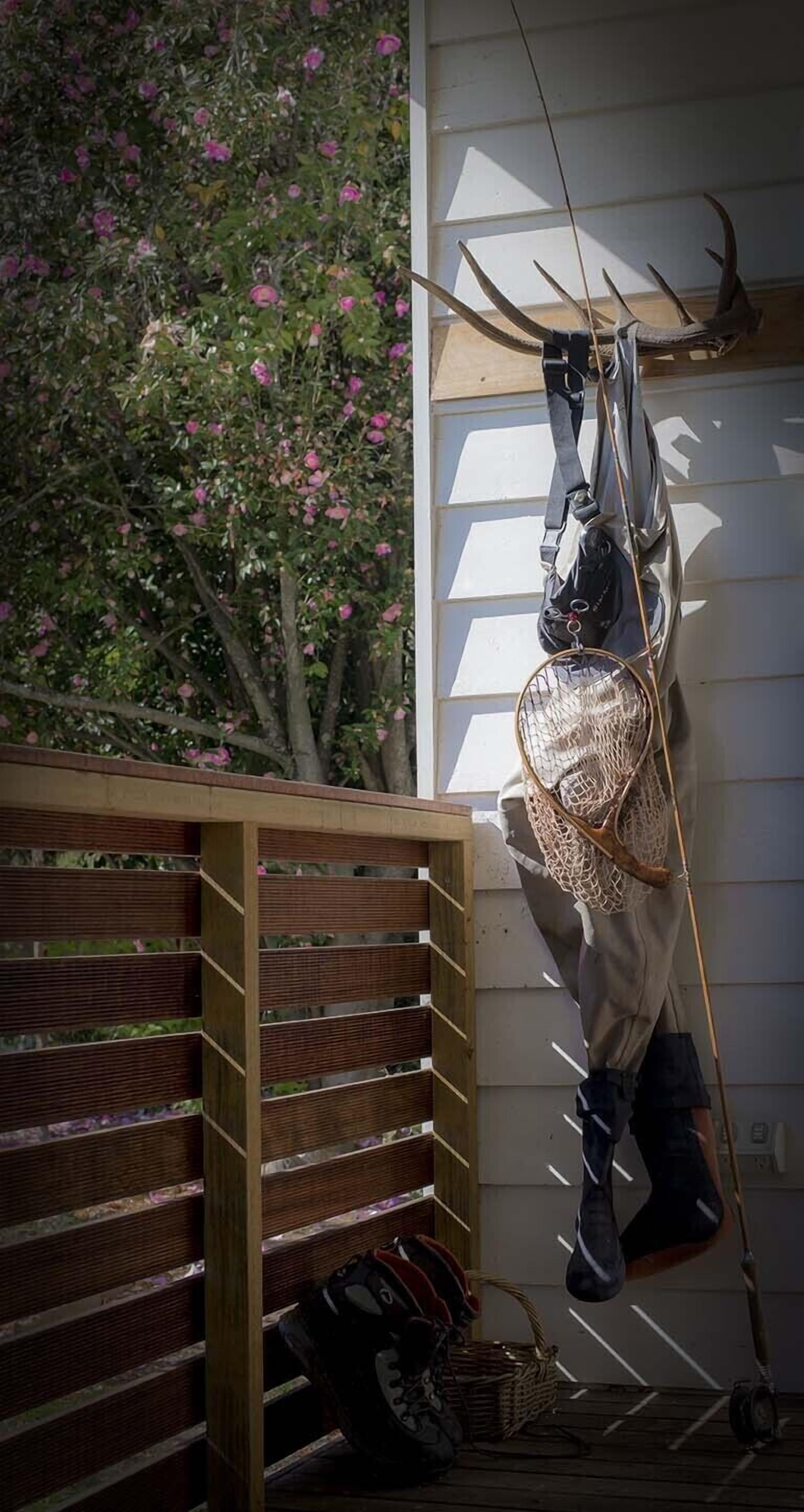 Une pièce comprenant un banc en bois à lattes, un panier en osier et un arc avec des flèches fixé au mur.
