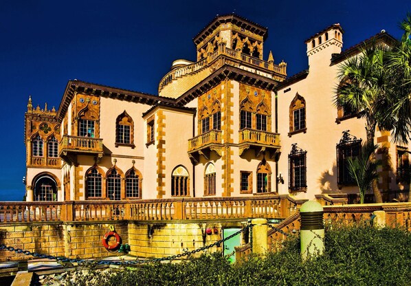 A historic building with multiple balconies, arched windows, and a prominent tower.