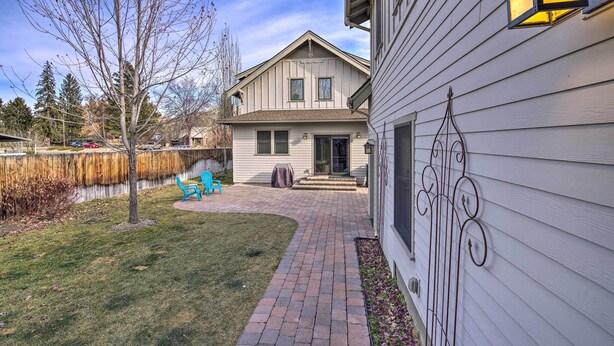 A two-story house with a brick pathway leading to the front door, a blue chair, and a small garden area. - River Street Roost - 12 Miles to Sun Valley Resort (Hailey)