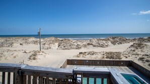 A wooden deck with a pool, overlooking a beach with dunes and the ocean. - Lightly Salted OBX, Beach front Luxury, Wild Horses, Pool, Hot Tub, 4x4 Beach (Corolla)