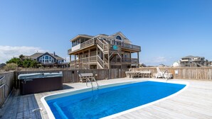 A wooden deck with a swimming pool, a hot tub, and outdoor furniture. - Lightly Salted OBX, Beach front Luxury, Wild Horses, Pool, Hot Tub, 4x4 Beach (Corolla)