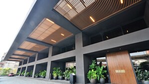 A modern building with a flat roof, large windows, and a series of potted plants along the entrance. - EST Link to LRT KL Sentral Bangsar (Kuala Lumpur)