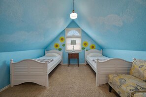 Attic bedroom with two twin daybeds and a sunflower mural