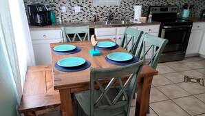 Un comedor con una mesa de madera y cuatro sillas, cada una con un mantel individual azul.