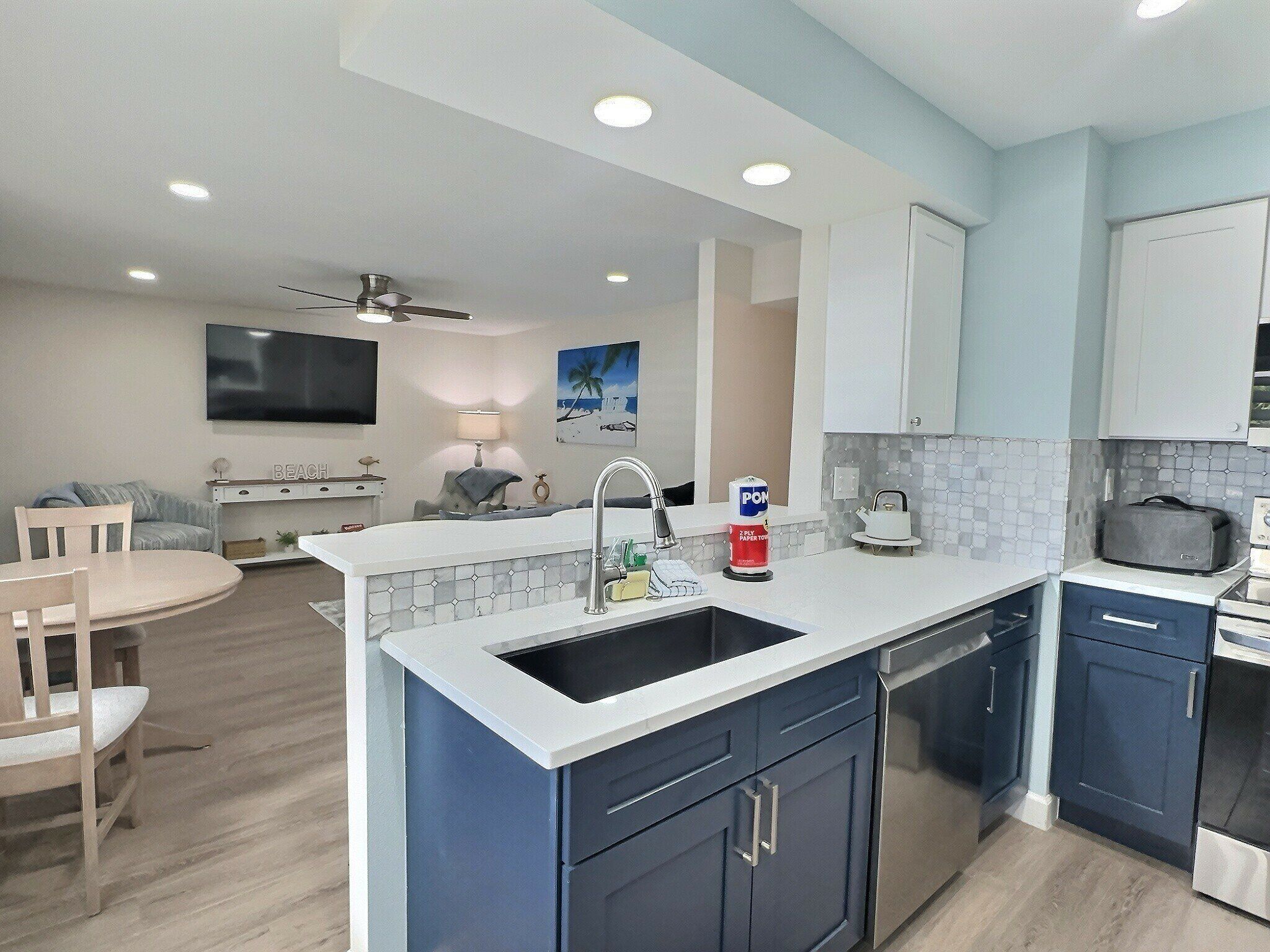 A modern kitchen with a central island, built-in cabinets, and a dining area with a table and chairs.