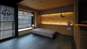 Una habitación con techo de madera, un banco, un ventanal con vistas y una pared con diseño decorativo.
