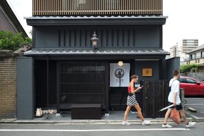 A traditional Japanese building with a dark facade, a tiled roof, and a lantern. - lili kyoto (Kyoto)