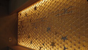 Una pared con un diseño geométrico, posiblemente un panel o biombo decorativo.