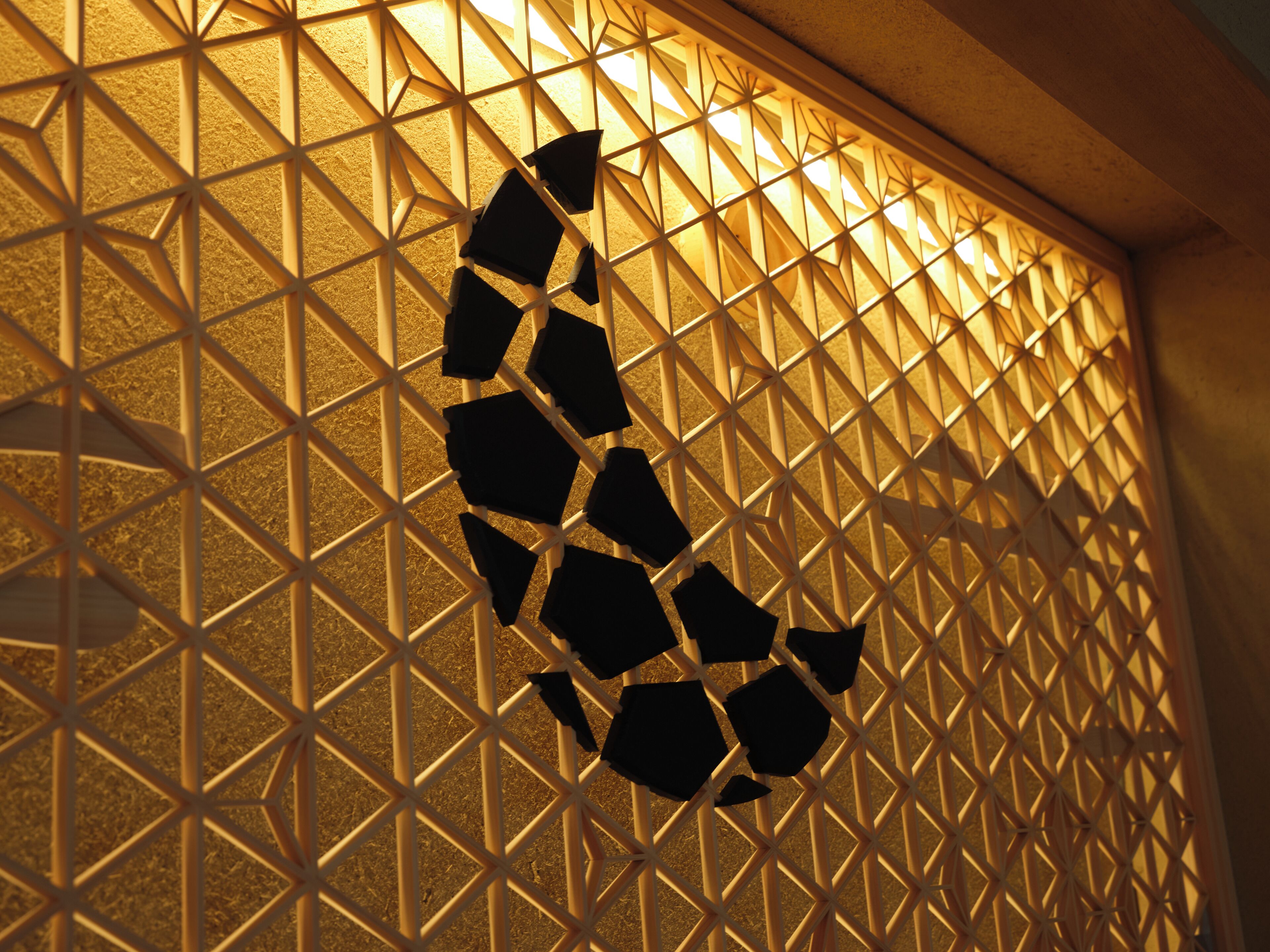 A geometric patterned wall with a series of interconnected shapes.
