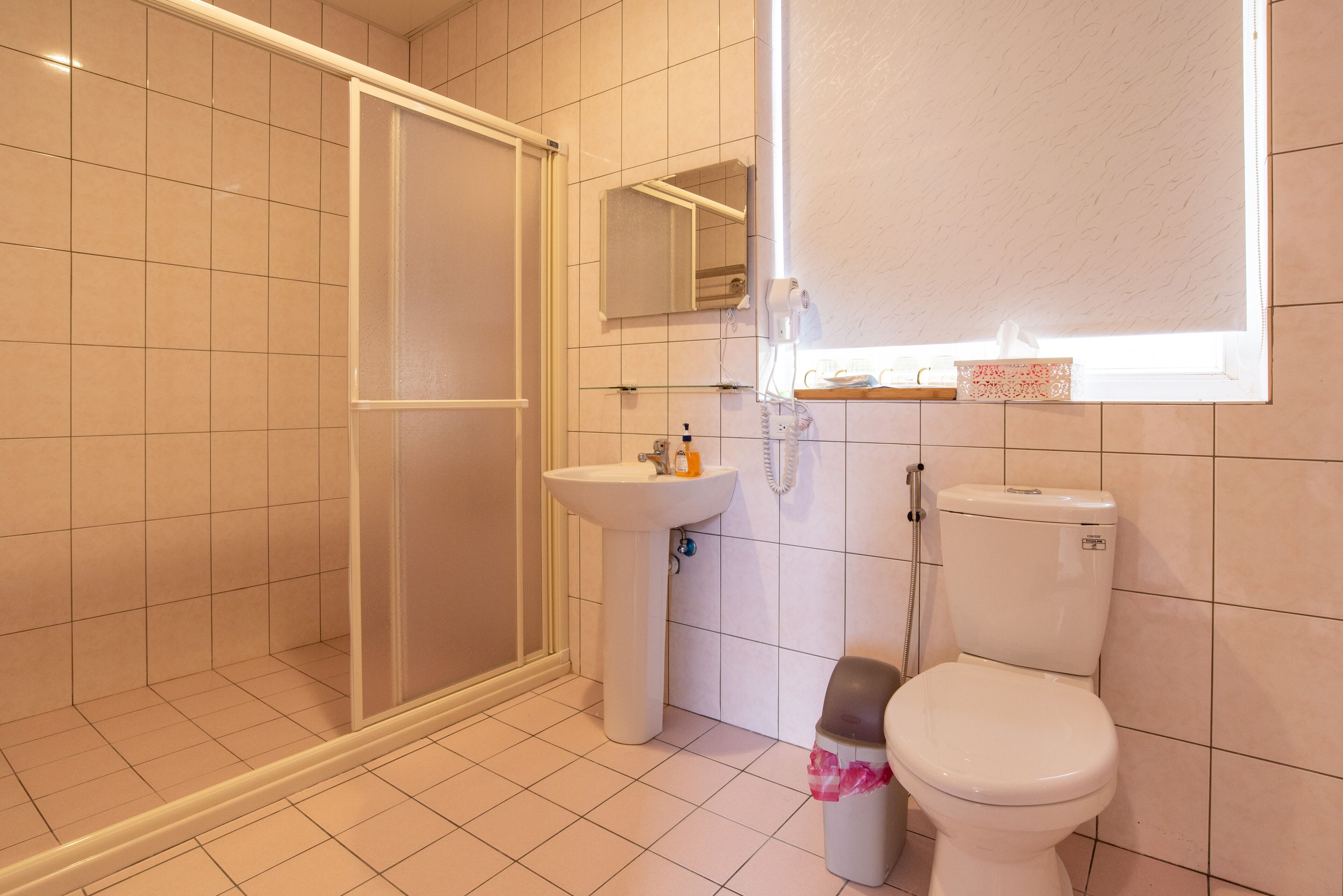 Un baño con ducha, lavabo e inodoro.