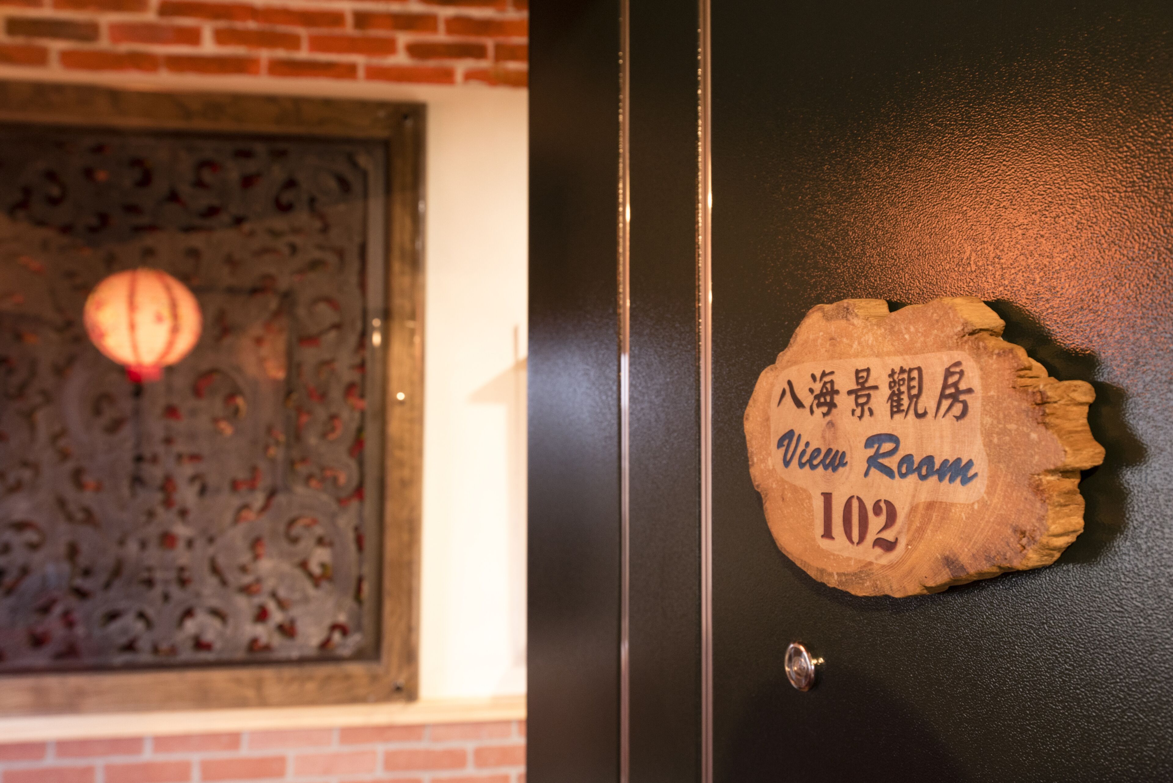A wooden plaque with "View Room 102" and Chinese characters on a black door.