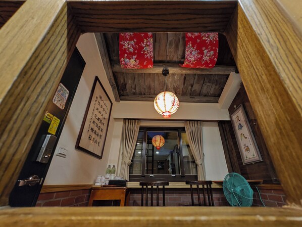 A traditional interior with wooden beams, a hanging lantern, and a framed sign on the wall. - Qu Hi Home Stay (New Taipei City)