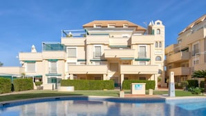 Un hotel de varios pisos con piscina al frente.
