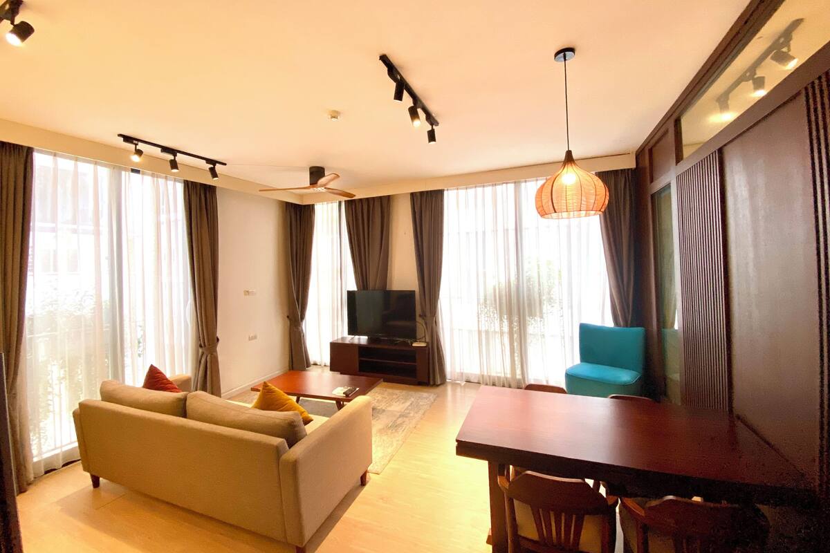 A living room with a sofa, TV, dining table, and chairs.