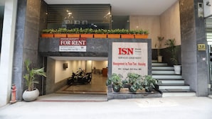 A serviced apartment entrance with a sign for rent, a reception area, and a staircase leading to the upper floor. - Apartment Kim Ma (Hanoi)
