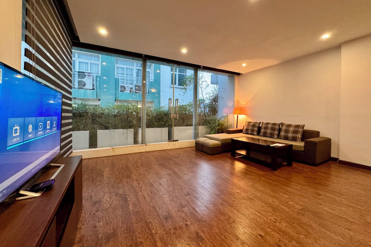 A modern living room with a flat-screen TV, a sofa, and a coffee table.